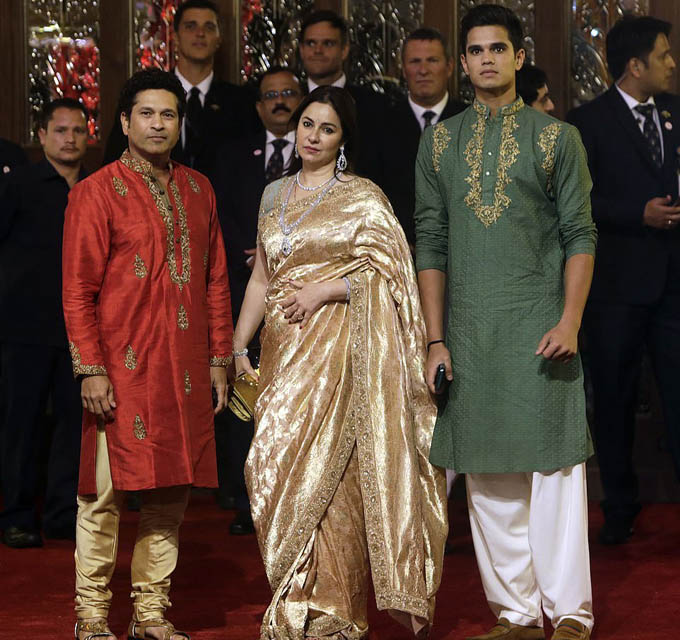 Former Indian cricketer Sachin Tendulkar, left, his wife Anjali and son Arjun join the VIP guests at the lavish Indian wedding